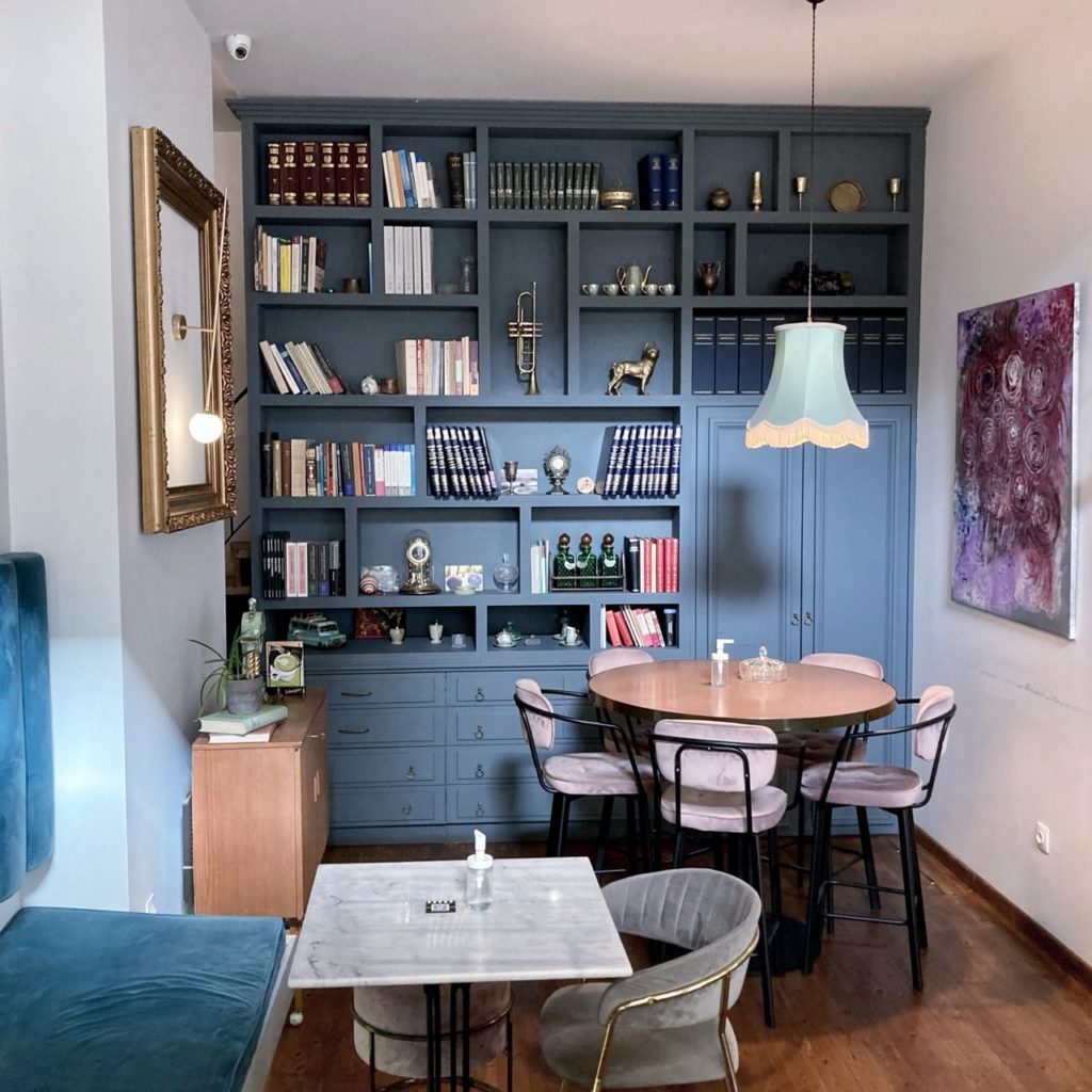 A built-in book wall with books in Mister Owl — a café in Athens